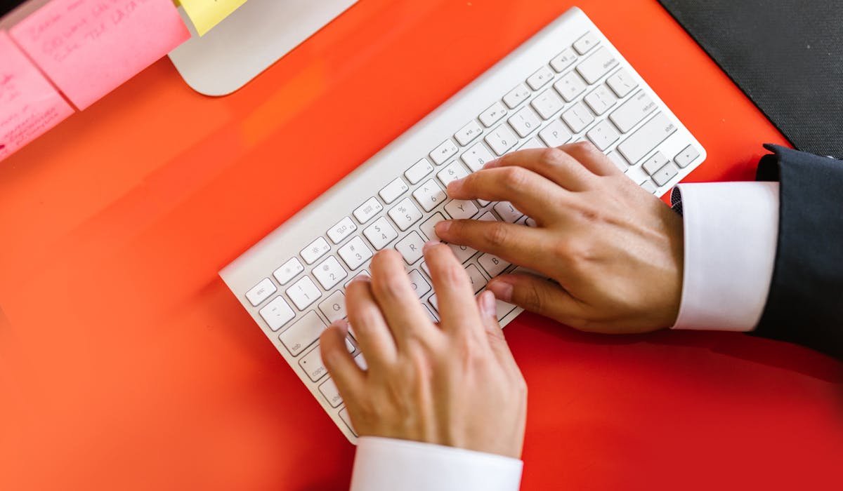 Person typing on laptop using ChatGPT - best ChatGPT prompts for productivity