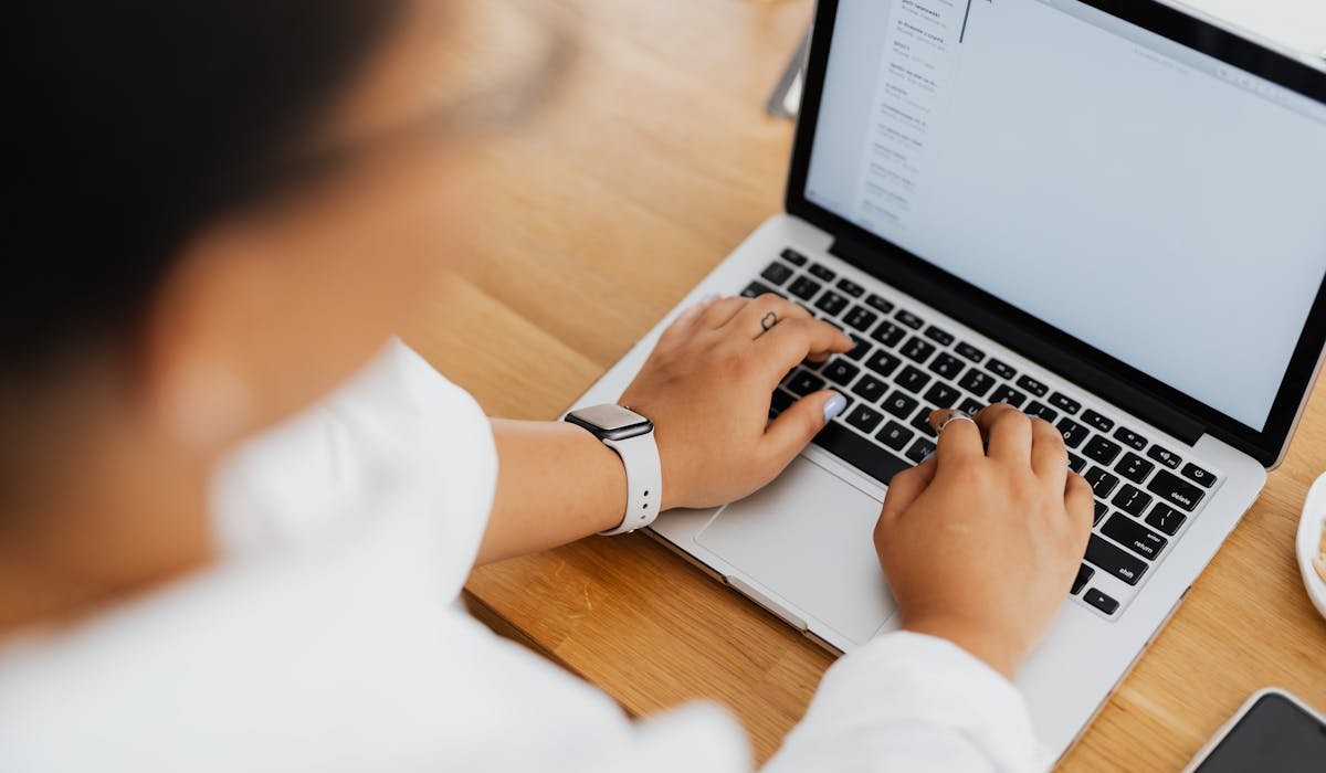 Person writing email on laptop with AI helper - how to use AI to write emails