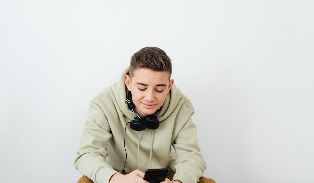 Person with headphones using phone - how to use ChatGPT voice mode
