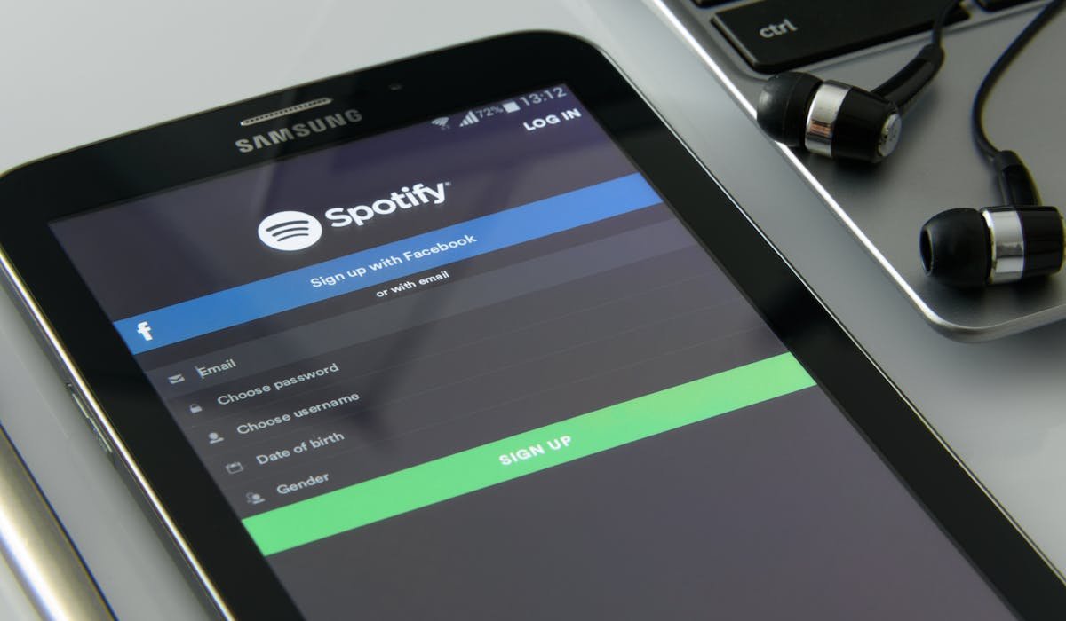 Person with headphones listening to music streaming - is Spotify Premium worth it review